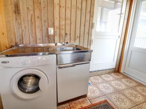 a laundry room with a washing machine and a sink at Holiday Home Dalia - 200m from the sea by Interhome in Vejers Strand