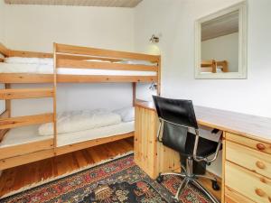 a desk and a chair in a room with bunk beds at Holiday Home Dalia - 200m from the sea by Interhome in Vejers Strand +16 photos