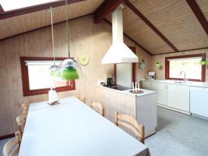 a kitchen and dining room with a white table and chairs at Holiday Home Harmke - 1km from the sea by Interhome in Vejers Strand