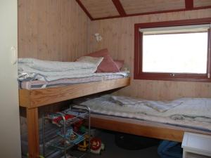 two bunk beds in a room with a window at Holiday Home Harmke - 1km from the sea by Interhome in Vejers Strand +5 photos