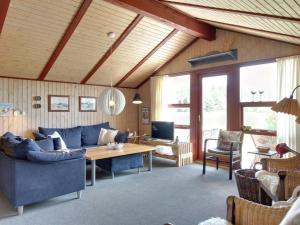 a living room with a blue couch and a table at Holiday Home Harmke - 1km from the sea by Interhome in Vejers Strand