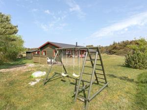 un'altalena in un cortile di fronte a una casa di Holiday Home Laiurenty - 1km from the sea by Interhome a Vejers Strand