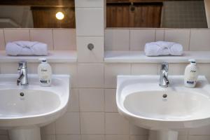 a bathroom with two sinks and two bottles of soap at Luxury Spacious 3 Bedroom, 3 Bathroom Apartment, Walk to Soho, West End, Covent Garden, China Town, Piccadilly in Minutes, Complimentary Fast WiFi, Tea & Coffee in London