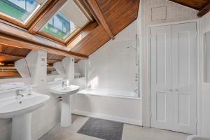 a bathroom with two sinks and a bath tub at Luxury Spacious 3 Bedroom, 3 Bathroom Apartment, Walk to Soho, West End, Covent Garden, China Town, Piccadilly in Minutes, Complimentary Fast WiFi, Tea & Coffee in London