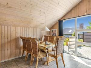 ein Esszimmer mit einem Holztisch und Stühlen in der Unterkunft Holiday Home Sanelma - 900m from the sea by Interhome in Vejers Strand