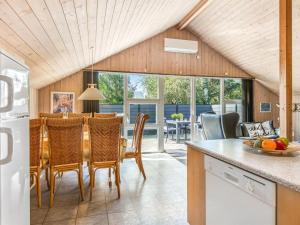 eine Küche und ein Esszimmer mit Tisch und Stühlen in der Unterkunft Holiday Home Sanelma - 900m from the sea by Interhome in Vejers Strand