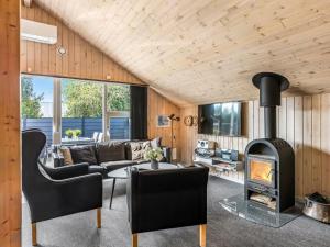 ein Wohnzimmer mit Kamin in einem Haus in der Unterkunft Holiday Home Sanelma - 900m from the sea by Interhome in Vejers Strand