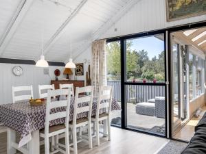 a kitchen and dining room with a table and chairs at Holiday Home Solvejk - 800m from the sea by Interhome in Vejers Strand
