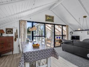 a kitchen and living room with a table and a couch at Holiday Home Solvejk - 800m from the sea by Interhome in Vejers Strand +19 photos