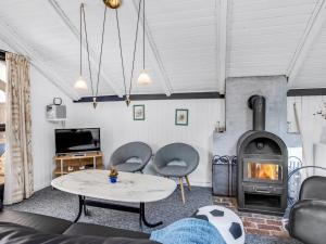 a living room with a table and a fireplace at Holiday Home Solvejk - 800m from the sea by Interhome in Vejers Strand
