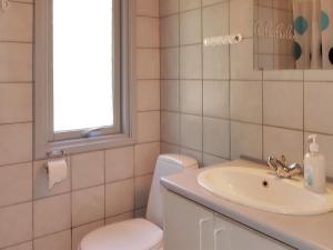 une salle de bain avec un lavabo et des toilettes et une fenêtre dans l'établissement Holiday Home Dane - 500m from the sea by Interhome, à Blåvand