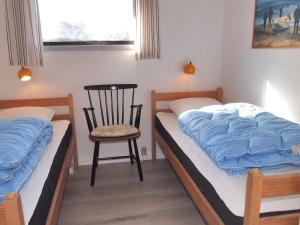 une chambre avec deux lits et une chaise et un lit dans l'établissement Holiday Home Dane - 500m from the sea by Interhome, à Blåvand 14 autres photos