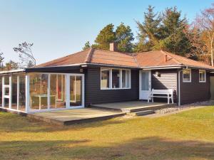 une petite maison avec un porche et une terrasse dans l'établissement Holiday Home Dane - 500m from the sea by Interhome, à Blåvand