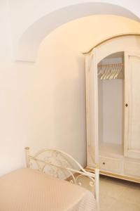 1 dormitorio con armario blanco y silla en Il Pumo Dorato, en Ostuni 17 fotos más
