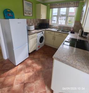 a kitchen with a white refrigerator and a dishwasher at Deja Blue in Sutton on Sea +9 photos