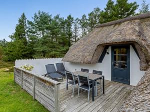 ブラーバンドにあるHoliday Home Lilo - 1km from the sea by Interhomeの茅葺き屋根の家。デッキにはテーブルと椅子が置かれている。