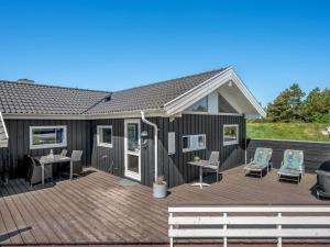 a large deck with two chairs and a table at Holiday Home Domna - 800m from the sea by Interhome in Blåvand