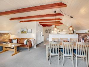 une cuisine et un salon avec une table et des chaises dans l'établissement Holiday Home Görel - 1km from the sea by Interhome, à Blåvand