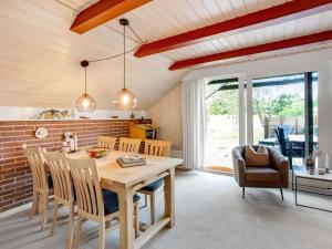 une cuisine et une salle à manger avec une table et des chaises en bois dans l'établissement Holiday Home Görel - 1km from the sea by Interhome, à Blåvand