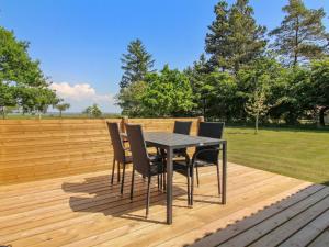 a black table and chairs on a wooden deck at Holiday Home Aswaldi - 3-5km from the sea by Interhome in Blåvand