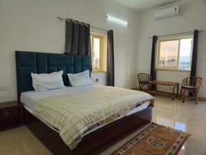 ein Schlafzimmer mit einem großen Bett mit blauem Kopfteil in der Unterkunft Hotel YesWell - Best Hotel Near Jolly Grant Airport in Doiwāla + 21 Fotos