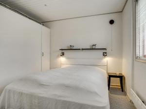 une chambre avec un lit blanc et une fenêtre dans l'établissement Holiday Home Skakke - 900m from the sea by Interhome, à Blåvand