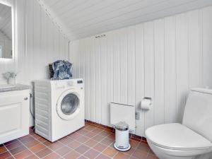 une salle de bains avec lave-linge et toilettes dans l'établissement Holiday Home Vladan - 1-6km from the sea by Interhome, à Blåvand
