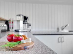 un comptoir avec deux tomates sur une planche à découper dans une cuisine dans l'établissement Holiday Home Vladan - 1-6km from the sea by Interhome, à Blåvand