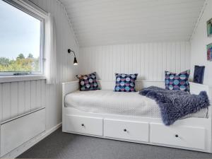 une chambre blanche avec un lit avec une fenêtre dans l'établissement Holiday Home Vladan - 1-6km from the sea by Interhome, à Blåvand 16 autres photos