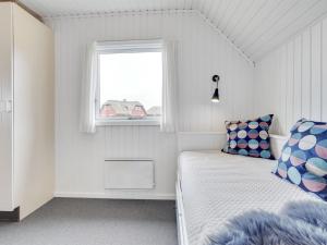 une petite chambre avec un lit et une fenêtre dans l'établissement Holiday Home Vladan - 1-6km from the sea by Interhome, à Blåvand