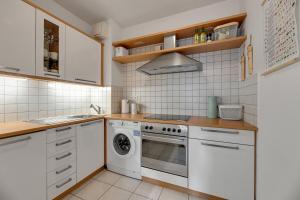 a kitchen with a stove and a washing machine at Grand Apartments Tulipan in Sopot +11 photos