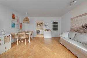 a living room with a couch and a table at Grand Apartments Tulipan in Sopot