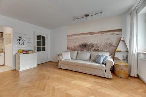 a living room with a couch and a painting on the wall at Grand Apartments Tulipan in Sopot