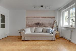 a living room with a couch and a painting on the wall at Grand Apartments Tulipan in Sopot