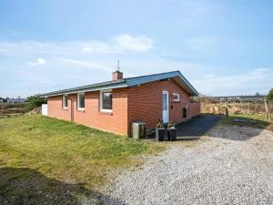 ein kleines rotes Backsteinhaus auf einer Kiesauffahrt in der Unterkunft Holiday Home Askatla - 800m from the sea by Interhome in Ringkøbing