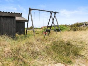 eine alte Schaukel auf einem hohen Gras in der Unterkunft Holiday Home Svenne - 500m from the sea by Interhome in Ringkøbing