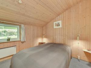 ein Schlafzimmer mit einem Bett in einem Zimmer mit einem Fenster in der Unterkunft Holiday Home Tali - 700m from the sea by Interhome in Ringkøbing