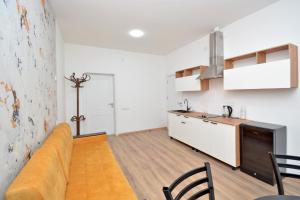 Una sala de estar con un sofá y una cocina. en Aparthotel Near Northern Avenue, en Ereván 5 fotos más