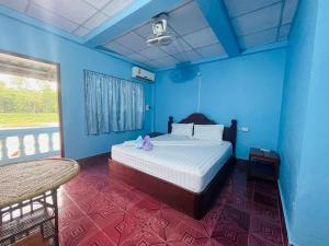 a bedroom with a bed in a blue room at Sipasert Guesthouse-Tadlo in Tad Lo