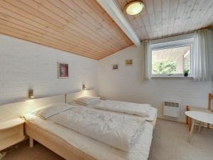 a bedroom with a large bed and a window at Holiday Home Nanette - 300m to the inlet by Interhome in Ringkøbing +17 photos