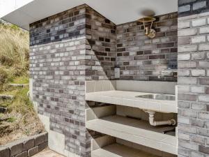 a bathroom with a sink and a brick wall at Holiday Home Edle - 300m from the sea by Interhome in Ringkøbing