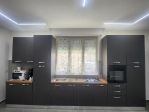a kitchen with black cabinets and a window at Naxos Blu Appartament in Giardini Naxos