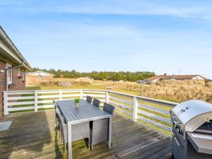 ein Tisch und Stühle auf einer Terrasse mit Grill in der Unterkunft Holiday Home Sissan - 900m from the sea by Interhome in Ringkøbing + 26 Fotos