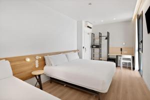 a bedroom with a white bed and a desk at B&B HOTEL Alicante Aeropuerto in Alicante