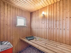 eine Holzsauna mit einer Bank und einem Fenster in der Unterkunft Holiday Home Yorik - 800m from the sea by Interhome in Hvide Sande + 16 Fotos