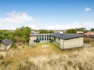 ein Haus auf einem Grasfeld in der Unterkunft Holiday Home Yorik - 800m from the sea by Interhome in Hvide Sande