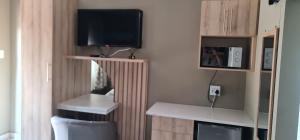 Una habitación con un televisor y un escritorio con un monitor y un televisor. en Villa king quest house, en Ga-Rankuwa
