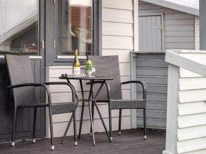 ein Tisch mit zwei Stühlen und einer Flasche Wein in der Unterkunft Holiday Home Trineke - from the sea by Interhome in Hvide Sande