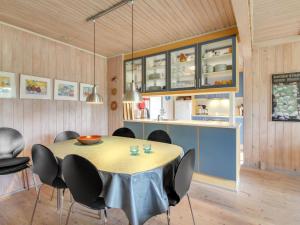une cuisine et une salle à manger avec une table et des chaises dans l'établissement Holiday Home Thurgot - 720m to the fjord by Interhome, à Bjerregård