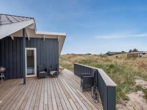 a house with two chairs on a wooden deck at Holiday Home Estella - 500m to the fjord by Interhome in Havrvig